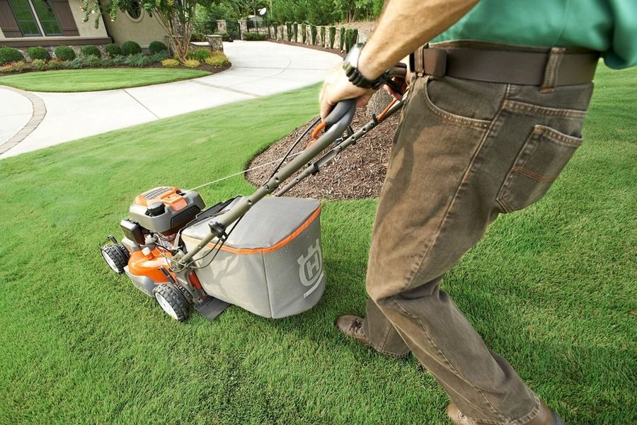 Landscaper pushing a mower, no face shown